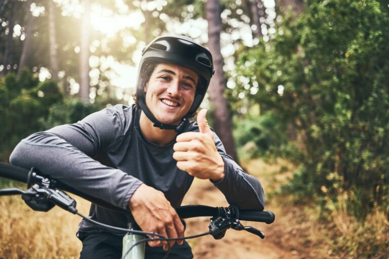 Thumbs up man rider on mountain bicycle happy riding or training for fitness, wellness and health e